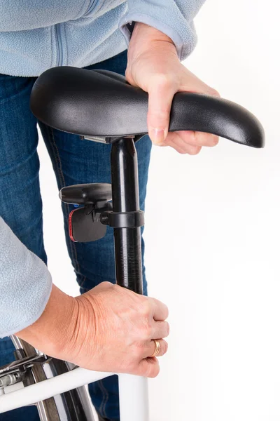 Mulher define altura da sela de bicicleta antes do ciclismo — Fotografia de Stock