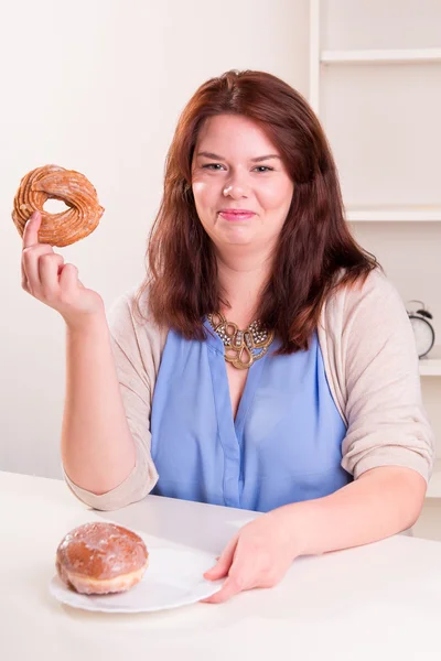 Knubbig kvinna anläggning donut — Stockfoto