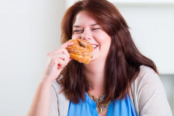 Plump woman eating donut — Stock Photo, Image