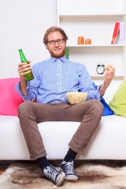 bira ve patlamış mısır ile TV izleyen adamım