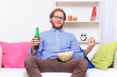 bira ve patlamış mısır ile TV izleyen adamım
