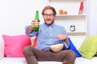bira ve patlamış mısır ile TV izleyen adamım