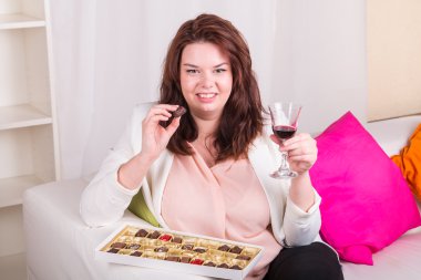 Plump woman with sweets and wine clipart