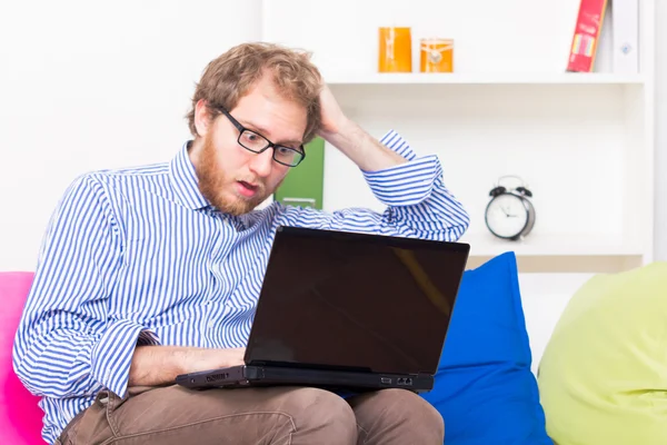 Mann arbeitet zu Hause mit Laptop — Stockfoto