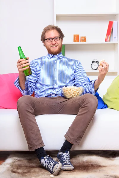 Homem assistindo tv com cerveja e pipoca — Fotografia de Stock