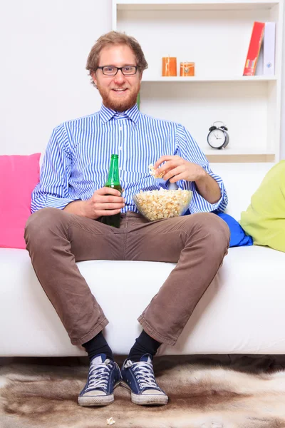 Człowiek przed telewizorem z piwem i popcorn — Zdjęcie stockowe