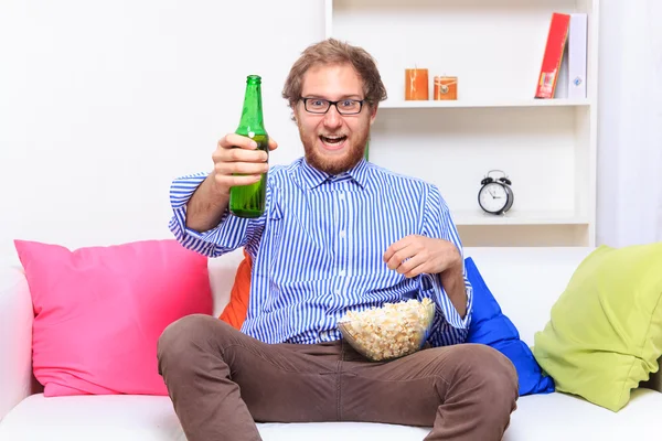 Man watching tv with beer and popcorn — Stock Photo, Image