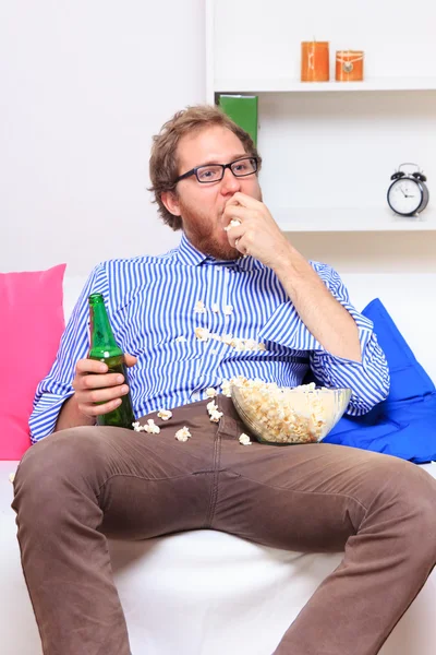Грустный человек с пивом и попкорном — стоковое фото
