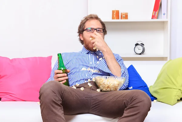 Бородатый мужчина с пивом и попкорном — стоковое фото