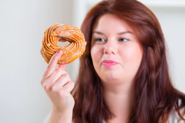 Mollige Frau isst Donut — Stockfoto