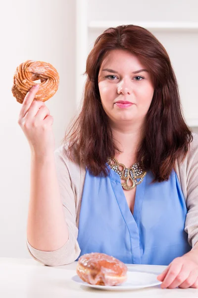 Пухнаста жінка їсть пончик — стокове фото