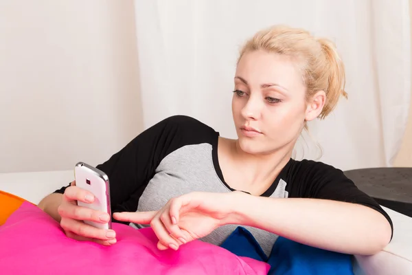 Blond girl holding smartphone — Stock Photo, Image