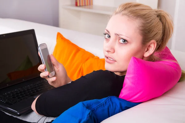 Unhappy girl with phone and laptop — Stock Photo, Image