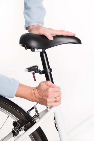 Woman setting bicycle saddle — Stock Photo, Image