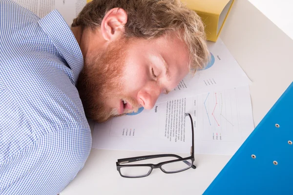 Arbeiter schläft auf dem Schreibtisch im Büro — Stockfoto