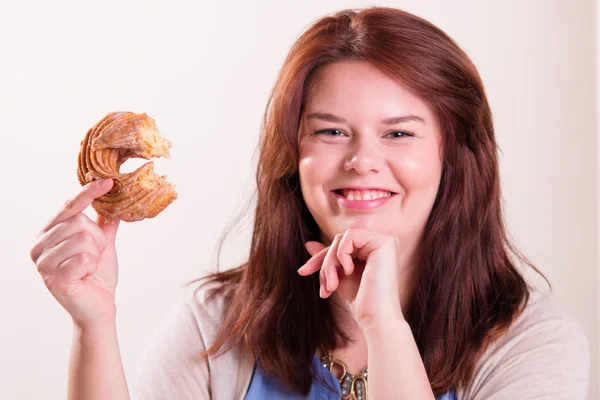 Tombul kadın donut yemek — Stok fotoğraf