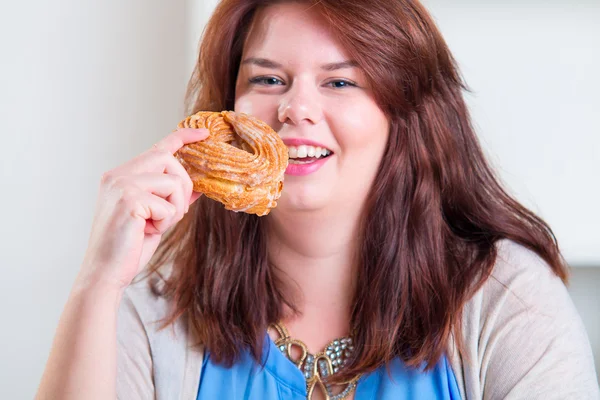 Lycklig kvinna äta donut — Stockfoto