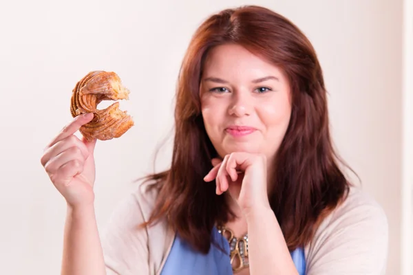 Plump woman eating donut — Stock Photo, Image