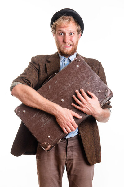 Terrified man in an old dress with a suitcase