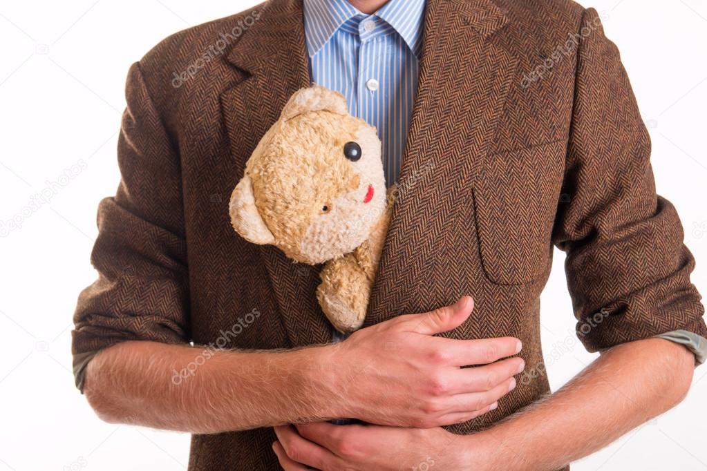 Old teddy bear in the arms of a man