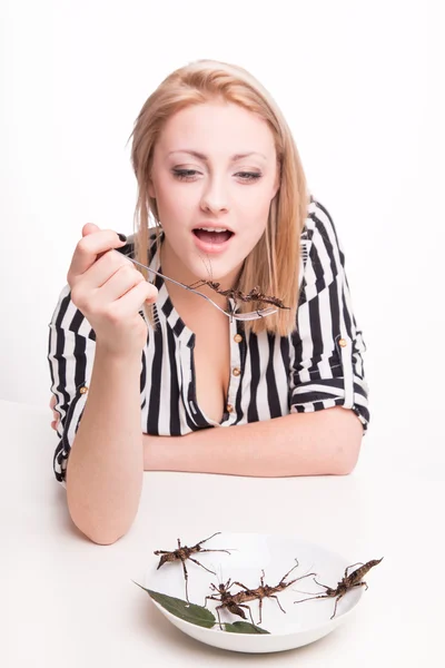 Woman eating insects with a fork — Stock Photo, Image