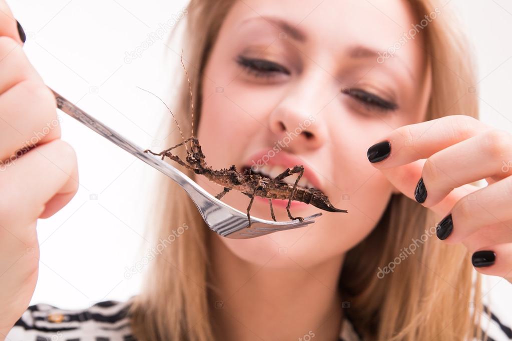 Woman eating insects with a fork