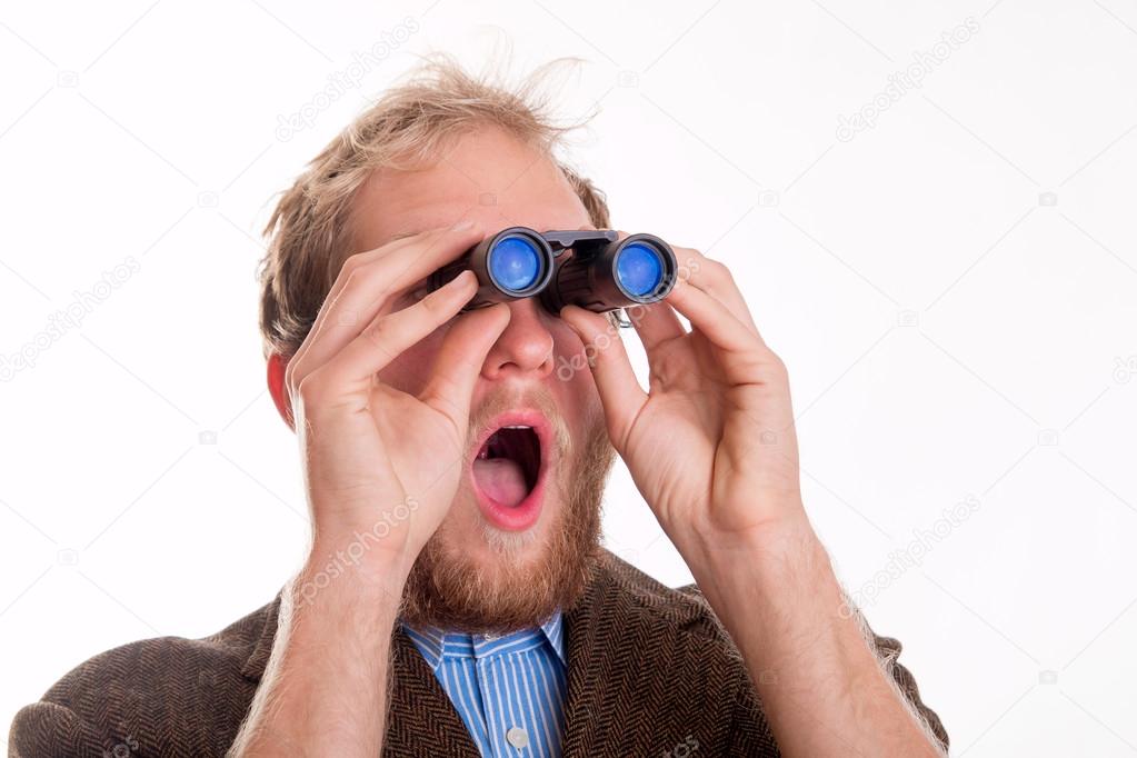 Shocked man watching through binoculars 