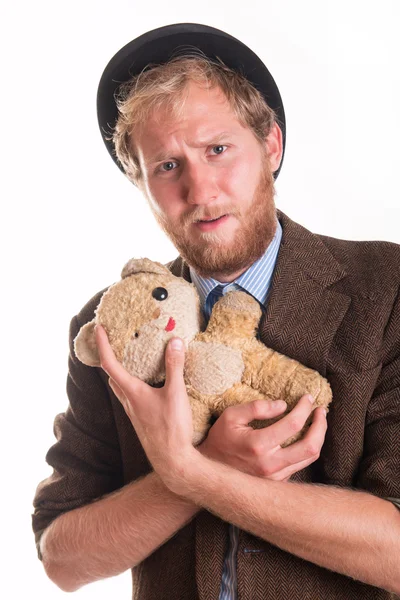 Unhappy old-fashioned man hugs an old teddy bea — Stock Photo, Image