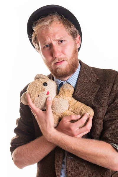 Unhappy old-fashioned man hugs an old teddy bea — Stock Photo, Image