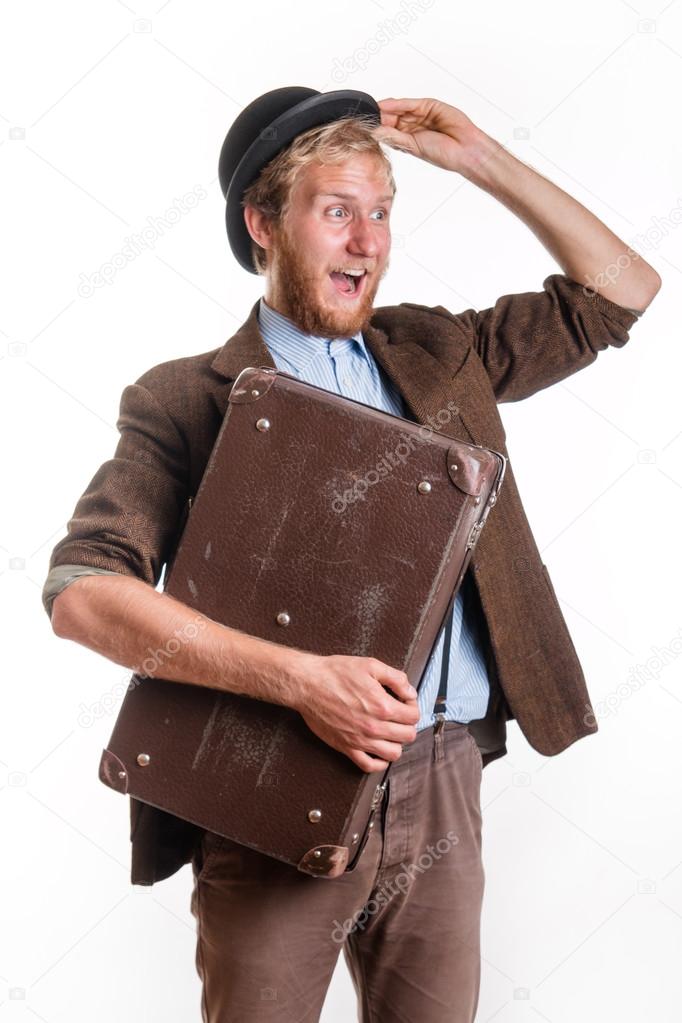 Cheerful bearded man in an old dress with a suitcase