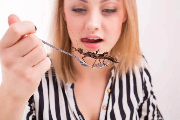 Woman eating insects with a fork — Stock Photo, Image