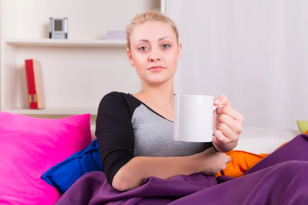 Frau auf Sofa mit Tasse Tee — Stockfoto