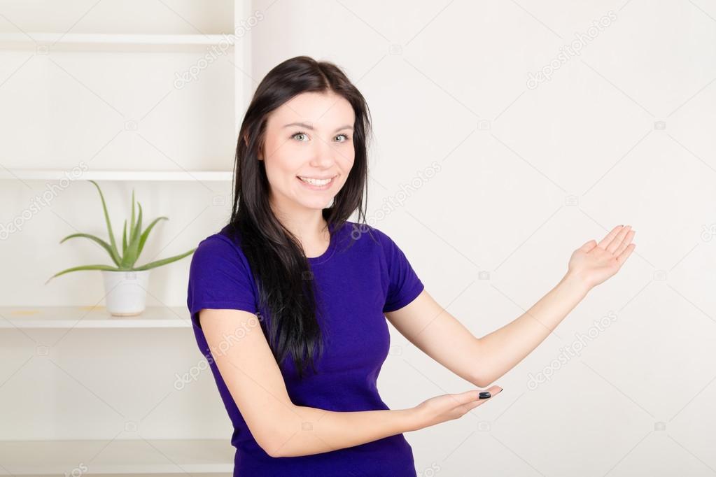 smiling girl pointing hands  on wall