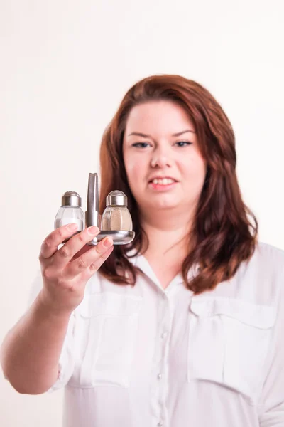 Girl  holding salt and pepper — Stock Photo, Image