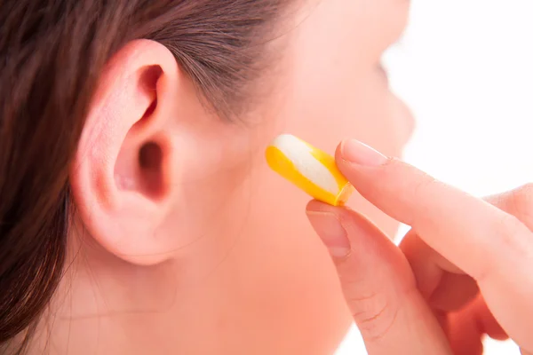 Mujer poniendo tapón auricular en el oído —  Fotos de Stock