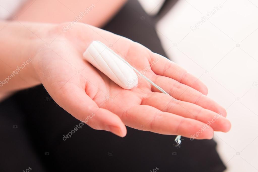 Woman holding intravaginal tampon