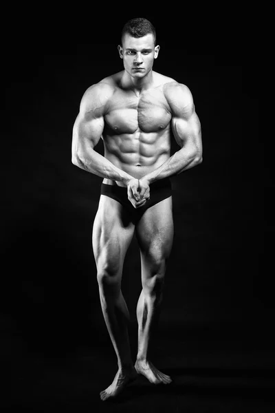 Kas fitness adam onun vücut üzerinde siyah backgro geliştirme sunar — Stok fotoğraf