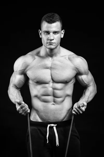 Mięśni fitness mężczyzna prezentuje jego ciało budynek na czarny backgro — Zdjęcie stockowe