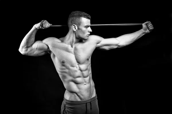 Mięśni fitness mężczyzna prezentuje jego ciało budynek na czarny backgro — Zdjęcie stockowe