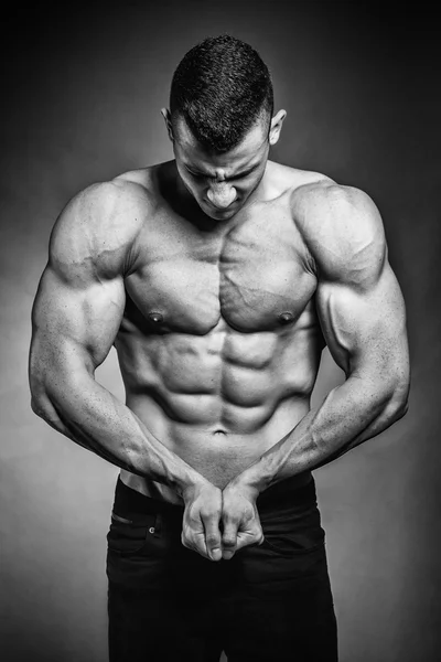 Musclé fitness homme présente sa musculation sur noir backgro — Photo