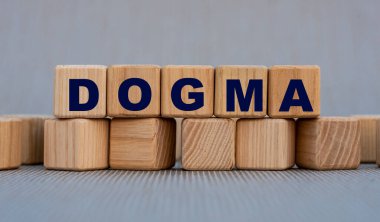 DOGMA - güzel gri bir arka planda tahta küplerle ilgili bir söz. İnanç psikolojisi kavramı.