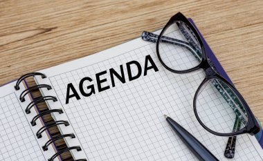 AGENDA kelimesi gözlüklü bir defterde yazılıdır.
