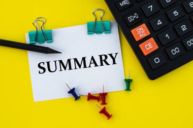 SUMMARY - hesap makinesi, düğme ve kalemle sarı arka planda klipsleri olan beyaz bir sayfada kelime. İş ve finans kavramı
