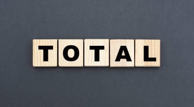 Gri arka planda tahta küplerin üzerinde TOTAL kavramı. İş konsepti