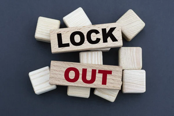 LOCK OUT - words on wooden bars on cubes on a gray background. Business and finance concept