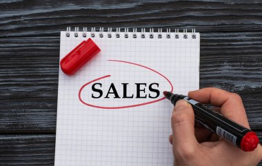 Bir kadının eli beyaz bir çarşafa siyah bir ahşap zemine 