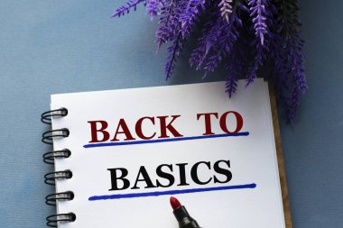 BASICS 'e dönelim. Gri bir arka planda, lavanta dallarıyla birlikte bir deftere yazılmış. İş konsepti
