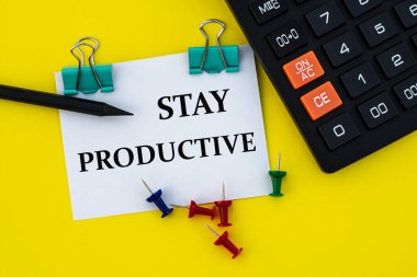 KALA PRODUCVE - beyaz bir sayfada kelime, sarı arka planda klipsli, hesap makinesi, düğmeleri ve kalemi olan. İş ve finans kavramı