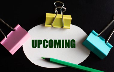 UPCOMING - beyaz kağıt üzerinde çok renkli ataç ve yeşil kalem ile kelime. İş konsepti