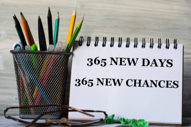 365 yeni gün 365 yeni şans, gözlüklü bir not defterindeki kelimeler ve bir kavanoz kalem. Eğitim kavramı